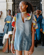 Woman wearing a sleeveless denim dress with colorful accents in an urban setting